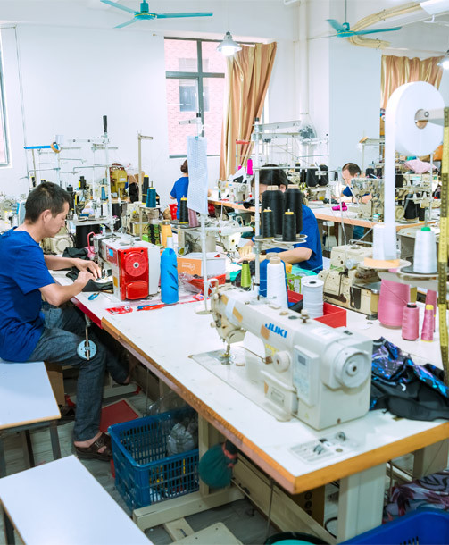 Sample development workshop at MinCharm's Dongguan factory with workers making garment samples