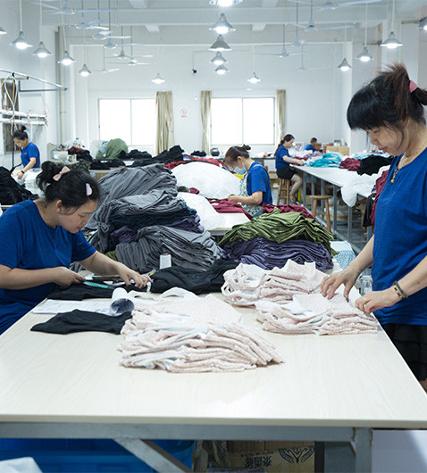 Garment workers checking and organizing finished apparel during production at MinCharm