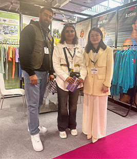 MinCharm team with trade show visitors at a UK apparel exhibition in 2024