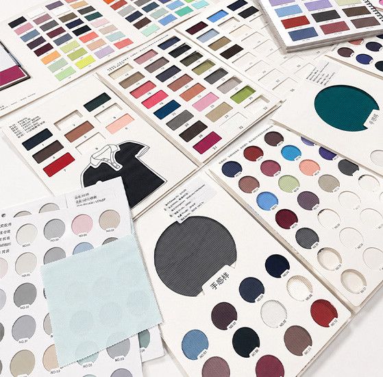 Fabric swatches and color cards reviewed for OEM apparel development at MinCharm