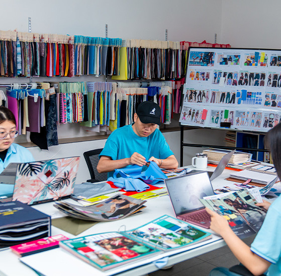 Product development team reviewing fabric swatches and apparel references at MinCharm