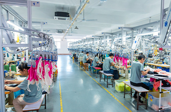 Garment workers sewing apparel on production lines at MinCharm's Dongguan factory