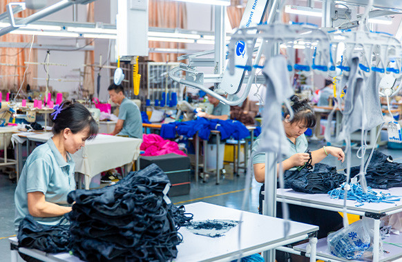 Workers handling garments during apparel finishing at MinCharm