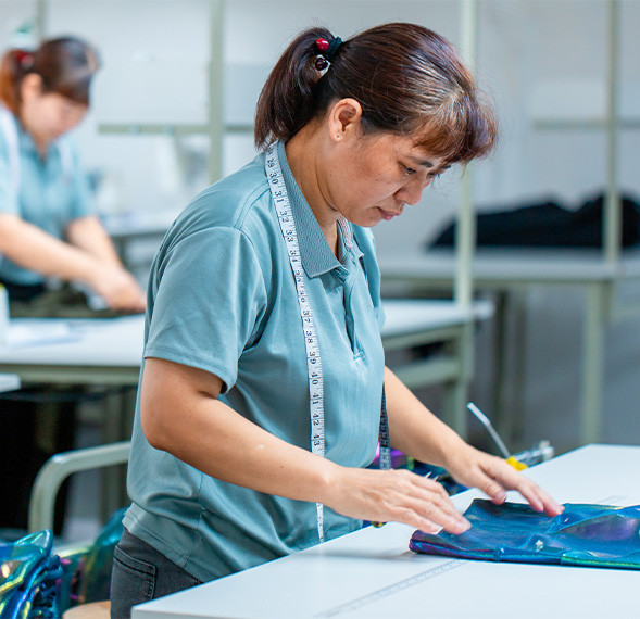Worker checking garment measurements during apparel production at MinCharm