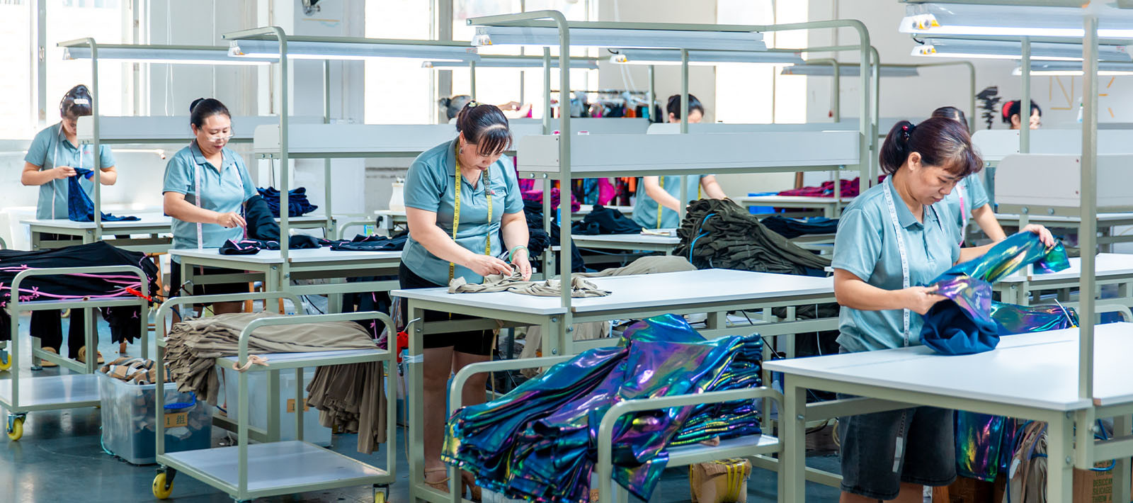 Workers checking finished garments during apparel quality control at MinCharm