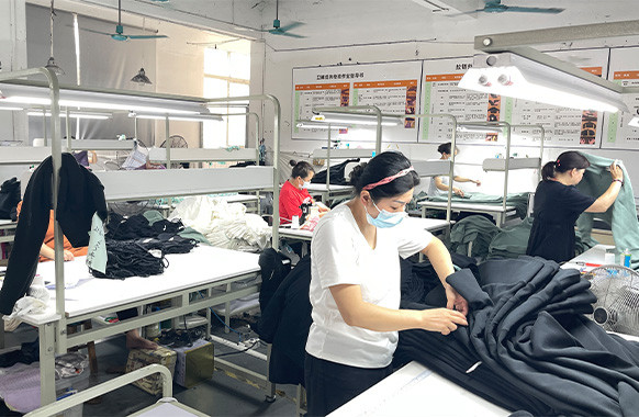 Workers inspecting bulk garments during apparel production at MinCharm