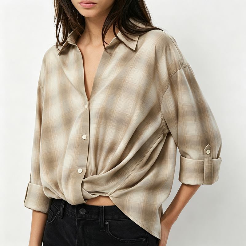 Close-up of women's beige plaid shirt collar and roll-tab sleeve