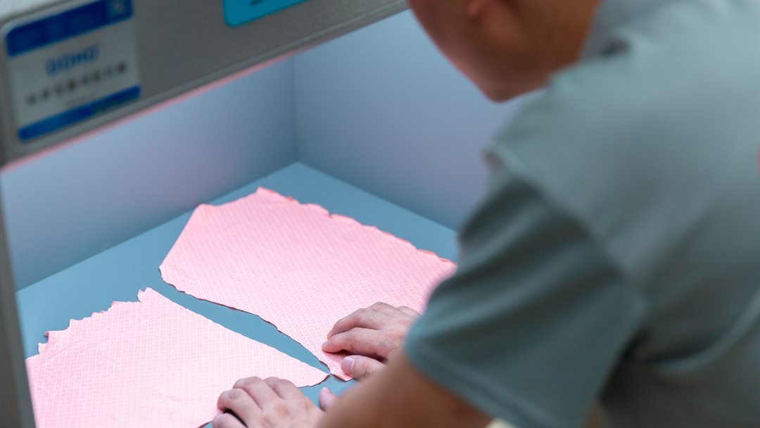 Technician positioning textile specimens for a garment material assessment