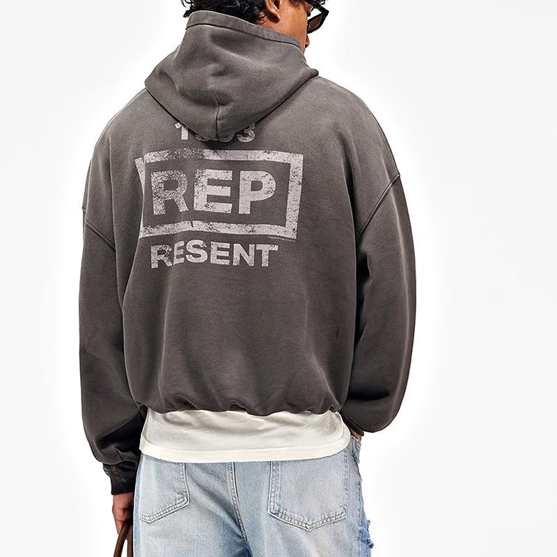 Back view of grey-brown drop-shoulder hoodie with distressed typographic graphic