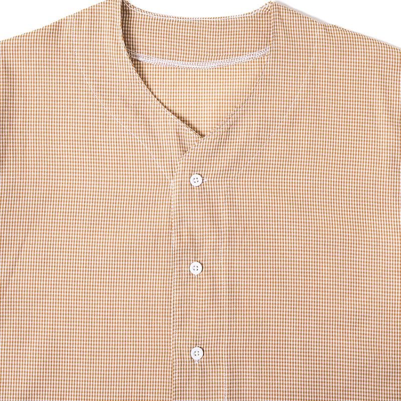 Close-up of collarless V-notch neckline and buttons