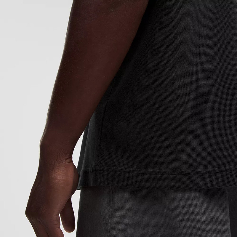 Close-up of black polyester T-shirt fabric and hem