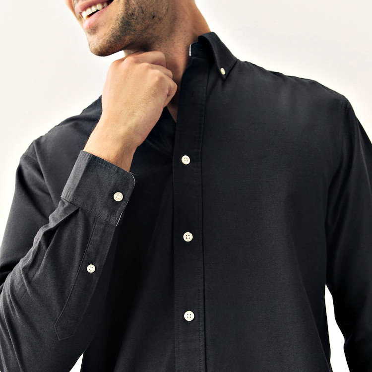 Button-down collar and long sleeve cuff detail on black shirt