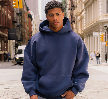 Male model wearing a navy pullover hoodie with a relaxed fit