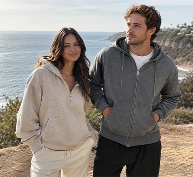 Models wearing neutral zip-up hoodies in an outdoor lifestyle setting