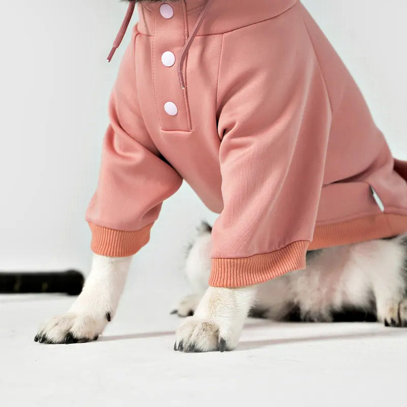 Pink dog hoodie close-up showing the three front snaps and ribbed short sleeve