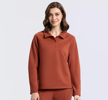 Woman wearing a rust-brown long-sleeve polo shirt.