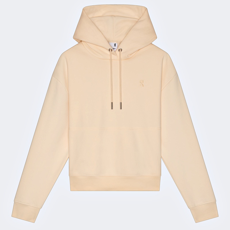 Close-up of the ribbed hem and cuff on a cream pullover hoodie