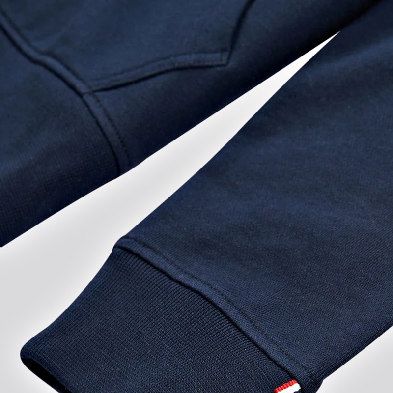 Close-up of raglan seam and ribbed cuff on a navy full-zip hoodie