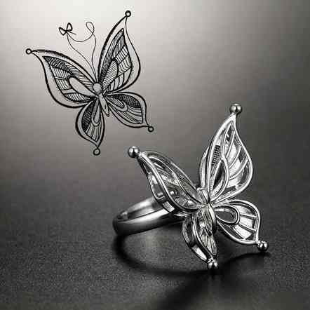 Butterfly-shaped 925 sterling silver ring next to its original hand-drawn design sketch