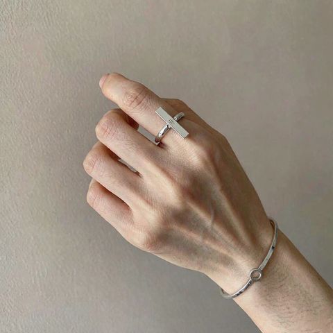 Hand wearing minimalist 925 sterling silver ring and bangle for daily wear care routine