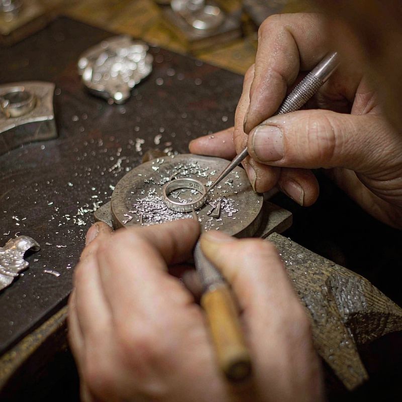 A craftsman finishing a silver piece by hand