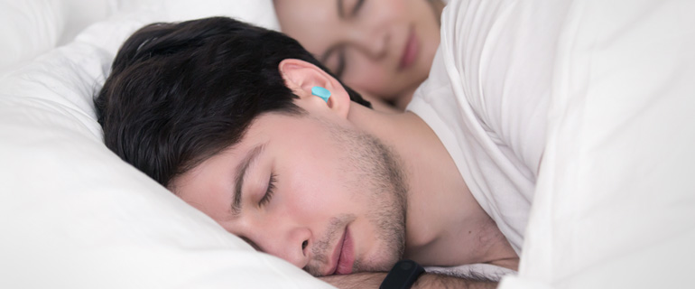 A man sleeping with foam earplugs